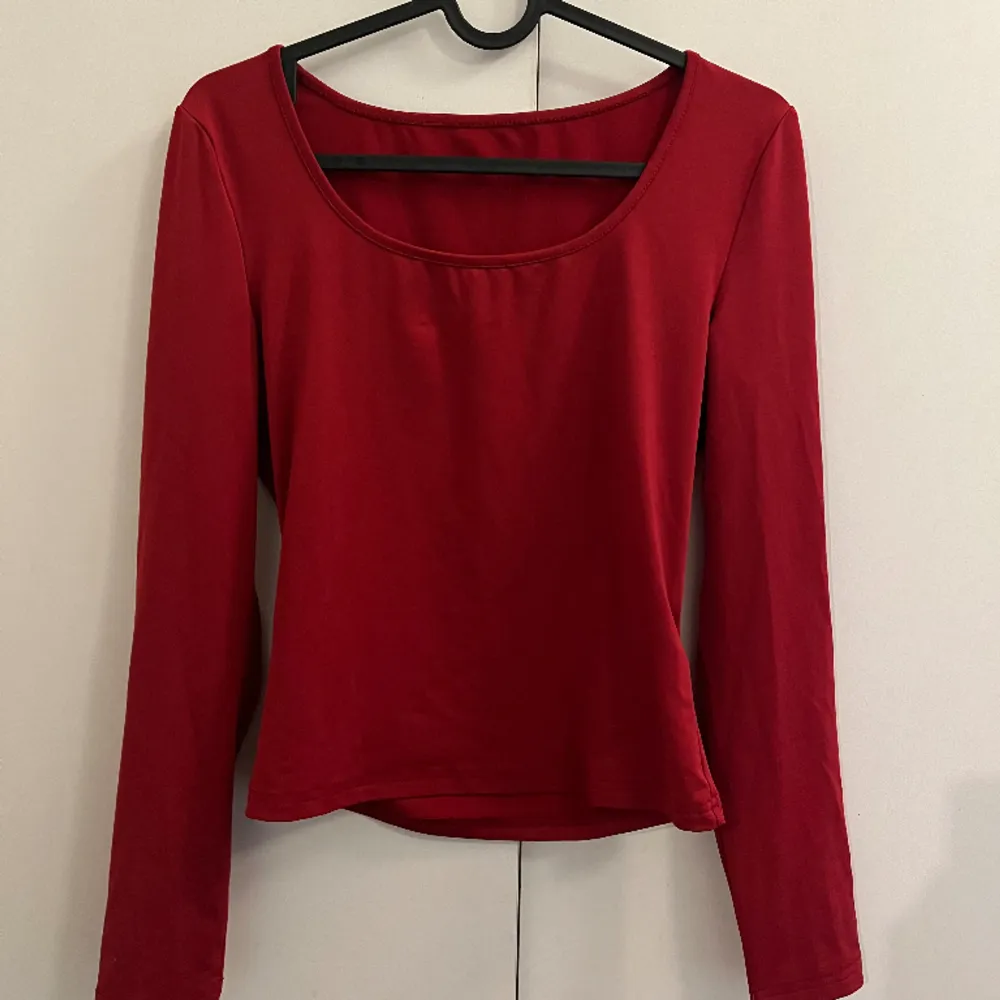 Röd tröja med lent/stretchigt material. Den har en mörkröd färg och sitter fint på. Använt väldigt få gånger. Toppar.