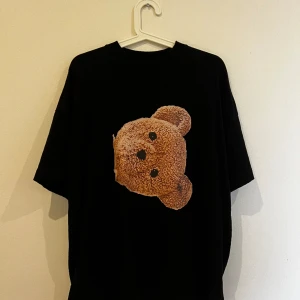 Palm Angels T-Shirt - Palm Angels T-Shirt Storlek: M (sitter tts, något loose i fiten) Skick: 8/10 (sparsamt använd, men med små cracks i trycket bak. Inget man tänker på om man inte verkligen försöker att leta efter det). Inköpt via Vestiaire.