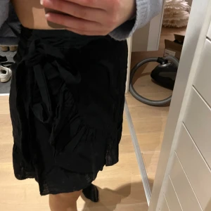 omlottkjol - Svart omlottkjol från Miss Milla i svart typ linnetyg, super fint skick och säljer då den inte kommer till användning! Pris kan diskuteras.