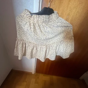 Sommar kjol och linne set -  Säljer ett sätt med två plagg en kjol och ett linne Sättet är gult med lila blommor på jättefint för sommaren skriv om ni är intresserade nästan aldrig använt bra skick