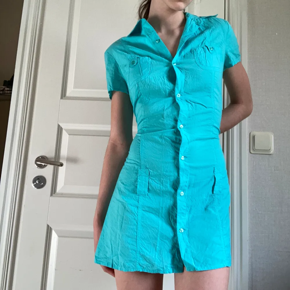  Jättefin blå skjortklänning med knappt hela vägen nering formar kroppen så fint🌟 Fina detaljer och fickor uppe på framsidan🌟 Jätteskönt material! Endast använt 1 gång så Nyttskick! 🌟. Klänningar.