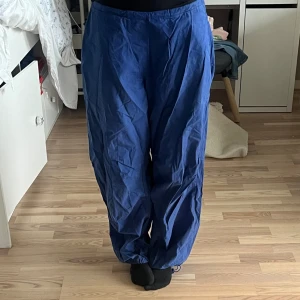 Parachute pants - Parachute pants från pull and bear!! 💙 säljer pga jag inte använder längre. Byxorna är skrynkliga då jag inte har strykt dem, men annars inga andra stora defekter!! Fickor på sidan och där bak! Justerbara i midjan och vid anklarna💙💙 strl M