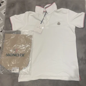 Moncler Pike - Hej, säljer denna nya vita Moncler pikén. Tag och påse ingår för endast 450 kr!