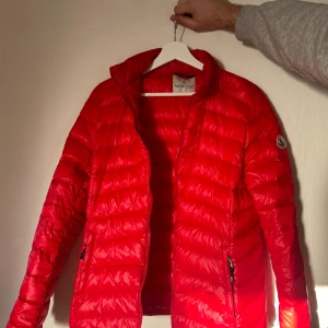 Röd Moncler jacka - Tunn fin jacka i dun, passar väldigt bra till vår och höst. Sparsamt använd. 