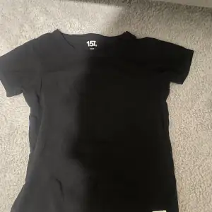 En svart basic t-shirt som har blivit för liten