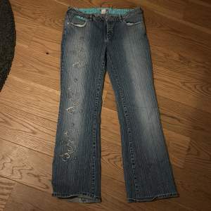 säljer dessa fina jeans med fina detaljer på ena benet (bild 2) i storlek 30, köpa på Beyond retro. Använda men i perfekt skick. kom privat för mer bilder/mått. 