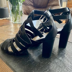 Svarta klackar - Svarta klackar med silverdetaljer. Köpta på skopunkten för längesen. 8cm klack.  Använda 1 gång. Säljer för att dom inte används. 