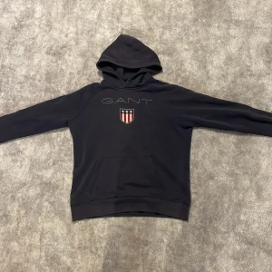 Gant hoodie - Säljer denna snygga Gant hoodie! Färg marinblå! Passar inte längre mig. Den har börjat tappa färg vid armbågen men inget som syns när man har på sig den! Storlek 170 Priset går att diskutera och om du har mer frågor är det bara att skriva!