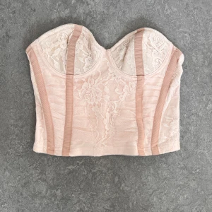 Korsett  - Kort korsett i spets med kupa utan push. Knäpps baktill med små hakar 