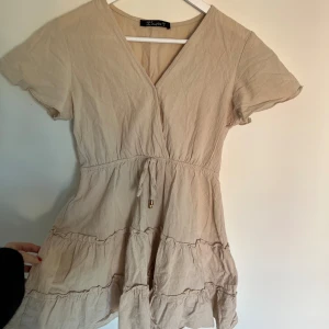 Somrig klänning i Linné - Kort klänning i linnématrial! Den är skrynklig från garderoben men det är bara att stryka🧸 den är urringad men finns en knapp att knäppa om man inte vill det🤎storlek S men sitter mer som en XS enligt mig🫧