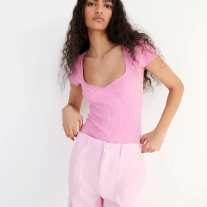 Rosa ribbad bodysuit från Zara - Säljer en superfin rosa ribbad bodysuit från Zara. Den har en snygg v-ringning och korta ärmar.💕💕Bodysuiten är i nyskick och väldigt bekväm att ha på sig. 