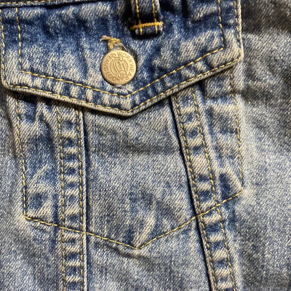 Säljer en superfin jeanskjol från Jeans for the Riot Girls. Den är i en klassisk blå jeansfärg och har en rad med knappar framtill. Kjolen har också två fickor med knappar på framsidan, vilket ger den en cool och avslappnad look. Perfekt för både vardag och fest! 🥳. Kjolar.