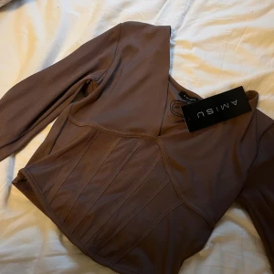 Topp säljes! - Topp säljes i en fin beigh brun färg, storlek L.  Den är aldrig använd, o prislappen sitter kvar på😇. Finns även en likadan i grått. Nypris: 119 kr Mitt pris: 85 kr!✨