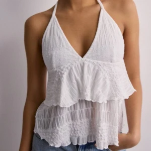 Volang linne - Säljer detta populär och snygga linnet j från Nelly med volanger och öppen rygg då den tyvär inte passar mig 💞 är som nyköpt! 