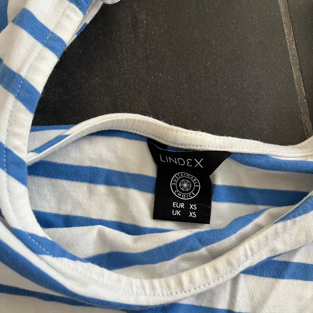 Säljer en superfin randig topp från Lindex i storlek XS. toppen är vit med blå ränder och har trekvartsärmar. Perfekt för sommaren.. Yläosat.