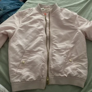 Bombarjacka  -  En ljusrosa bombarjacka superfin med ett hjärta ristat på dragkedjan från H&M kanske sen storlek 140  9-10 år 