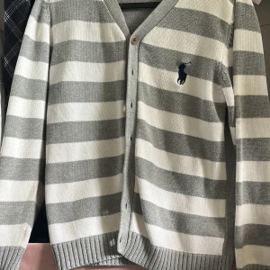 Tröja  - En randig vit grå tröja med knappar på 