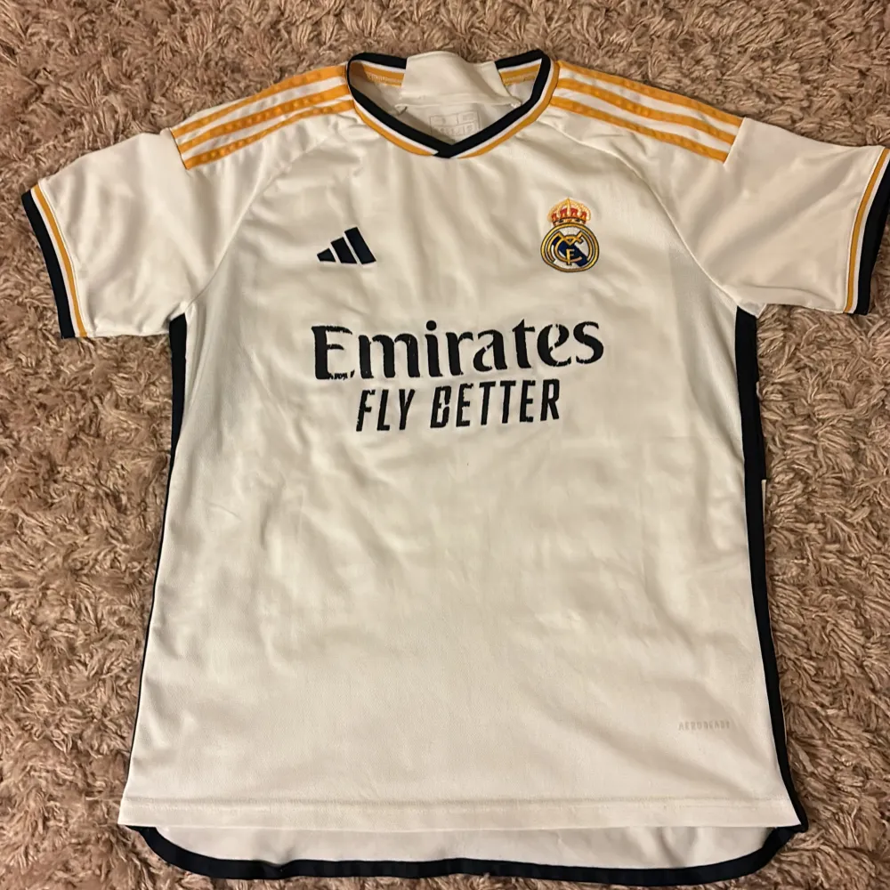 En real Madrid fotbolls tröja som är använd, texten har eller håller på att ramla av vid vissa ställen på tröjan men därför säljes så billigt. Vid fler frågor är det bara att skriva . Sportswear.