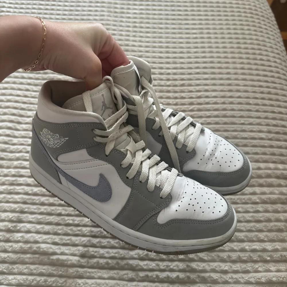 Säljer ett par snygga Nike Air Jordans Mid Wolf Grey Skorna är i bra skick och har en klassisk design med snörning. Lite crease med det händer tyvärr med alla skor. Har för många jordans hemma. Köpte för 3200. Storlek 39. Skor.