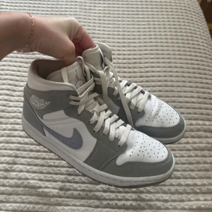 Nike Air Jordans i grått och vitt - Säljer ett par snygga Nike Air Jordans Mid Wolf Grey Skorna är i bra skick och har en klassisk design med snörning. Lite crease med det händer tyvärr med alla skor. Har för många jordans hemma. Köpte för 3200. Storlek 39