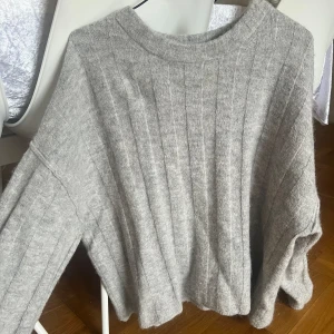 Grå Stickad tröja - Säljer denna super fina stickade tröjan från Gina då jag redan har en liknade jag använder mer. Super fint skick använt få gånger men sparsamt. Säljs för 200