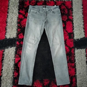 Grå jeans från Jack & Jones - Säljer ett par grå jeans från Jack & Jones i storlek 36/34. De är i slim fit-modell och har en snygg, tvättad grå färg. Perfekta för både vardag och fest! De har en klassisk femficksdesign och stängs med knapp.