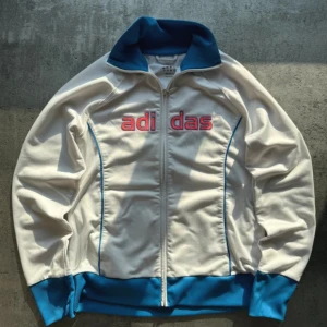 Adidas Vintage Track  - Size: M/L  Mått:  Bröst - 50cm  Längd - 60cm (Jag rekommenderar att kolla måtten eftersom den egentliga storleken kan avvika från den uppskattade storleken.) Skick: 9/10, något enstaka tecken på användning men inga defekter alls. SÄLLSYNT PLAGG 