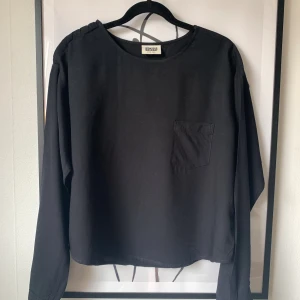 Långärmad topp / blus - Weekday - Svart långärmad topp från Weekday. Knappdetalj på vänster axel. Storlek XS. I mycket fint skick 🌸