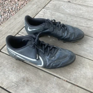 Fotbollsskor  - Svarta Nike fotbollsskor. Fotbolls skorna är lite slita och använda men perfekta om du vill testa på fotboll men inte vill köpa för dyra skor. Skosnörena är slita längst ut vilket man ser på bilderna. Strl: 40,5.⚽️🤩