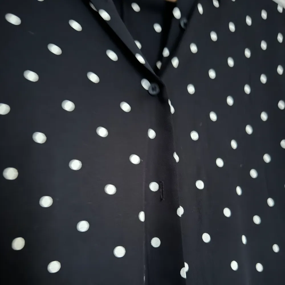 Svart t-shirt blues med vita prickar och knappar från Uniqlo i nyskick! Storlek XS, men passar upp mot M.. Blusar.