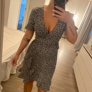 Fin klänning - Fin blommig klänning, finns ett spänne innanför. Lite urringad men går att sätta en säkerhetsnål om man vill. Lapp bortklippt så vet inte vart den är ifrån.