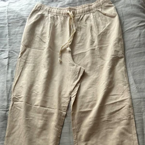 Linnebyxor  - Beiga linnebyxor, vida i benen. Helt oanvända i storlek XL.