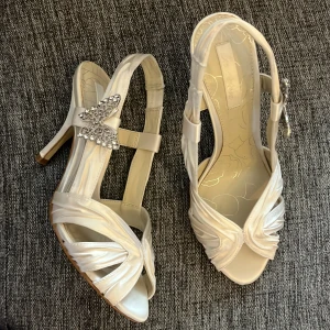 Klackar med fjäril - Fina klackar. Aldrig använda enbart testat. Köpt på Plick. 💕   Färgen är vit med en satinlik material. Väldigt fina skor men kommer inte till användning.  De är i väldigt bra skick🫶  Frakt ingår ej❤️ Hör av er vid frågor eller funderingar💕