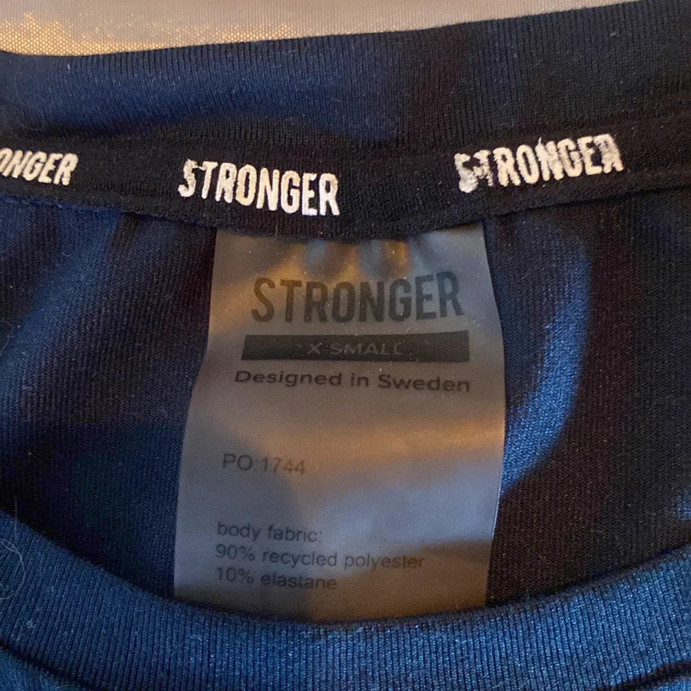 Träningströja med stronger-märke. Polyester. T-shirts.