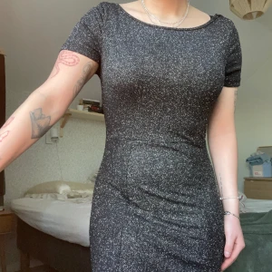 Kortärmad glittrig klänning - Säljer denna fina glittriga klänning med öppen rygg i storlek S. Jag är 163cm. Köparen står för frakten