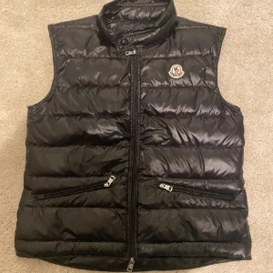 Moncler Gui väst - Moncler väst, självklart äkta och kvitto från NK finns. Bra skick och sparsamt använd. Nypris 8000, skick 9/10. Skriv för fler frågor/Carl