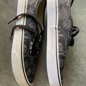 VANS Van Doren Black/Aloha Skull - VN-0 VOEC78 US M 10 Äldre modell, högersko har gulnat något (se sista bilden), oanvända Prismärkt låda, något defekt