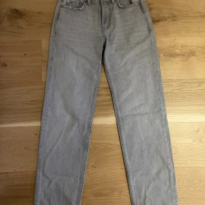 Gråa lågmidjade jeans - Lågmidjade jeans från Gina Tricot.  Lite slitage nere vid benen, skriv för tydligare bilder. Annars i nyskick.