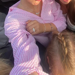 Rosa randig skjorta - Jättefin skjorta som är v-ringad och ganska loose fit. Snygg men har använts för sällan. Som man ser på sista bilden är materialet på tyget lite ”buckligt/räfflat” och inte att den är ostrykt!