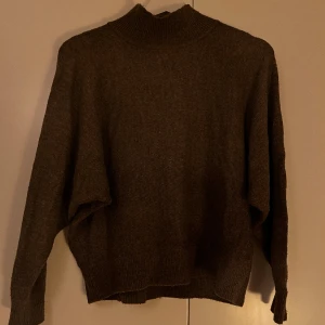 Brun stickad tröja  - Brun stickad tröja med halv polo. 