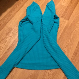 En topp - En blå topp med urringning både bak o fram, den sitter tajt. Storlek XXS. De finns en fläck på en arm men ingenting man tänker på. Den syns inte alls nästan❤️