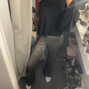 Glittriga byxor  - Så fina byxor som endast är använda en gång. Inga defekter alls och så snygga. Storlek xs och jag är 165 cm lång. 