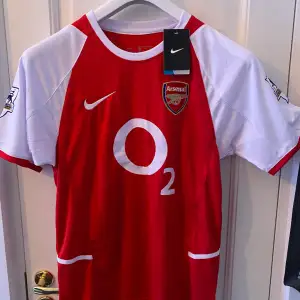Arsenal tröja från säsongen 2002-2004 med Bergkamp på ryggen. Ett måste för er Arsenal fans. Tröjan är helt ny med tags och av högsta kvalitet. Hör gärna av er vid frågor och funderingar 📦