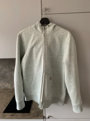 Carhartt hoodie storlek XL - Jättefin hoodie ifrån carhartt, storlek XL. Vit med lite turkosa inslag.