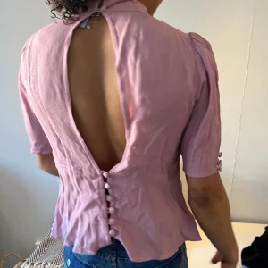 Rosa blus - Fin och unik blus som är öppen där fram och bak. En knapp saknas men blusen är super fin ändå.