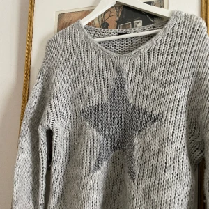 Grå stickad  - Superfin geå stickad tröja med silvrig stjärna på!