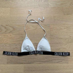 Calvin Klein - vit bikiniöverdel  - Säljer min vita Calvin Klein överdel då den ej kommit till användning och är därför i mycket gott skick! Storlek S 😊