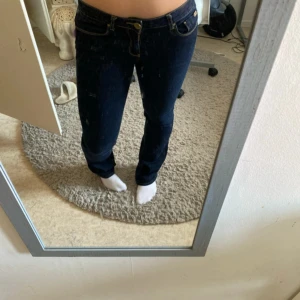 Zara lågmidjade jeans - Supersnygga, mörkblåa, utsvängda och lågmidjade jeans. Dem har även snygga bakfickor med pärlor på. 