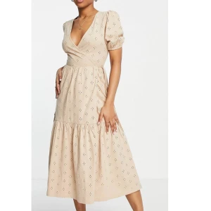 Sandfärgad broderad omlottklännings  - Omlottklänning från ASOS i storlek 38. Som ni ser är prislappen kvar, har aldrig haft tillfälle att ha på mig den tyvärr. 