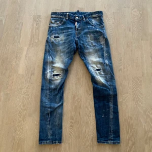 Knappt använda Dsquared2 jeans i bra skick  - Vi säljer ett par 100% äkta knappt använda  dsquared2 jeans i bra skick. Färgen på jeansen är både grön och vit. Passar dig från 160 till 165 cm. Mellan åren 12-14. Vårt pris 799kr och nypris 3200kr. 